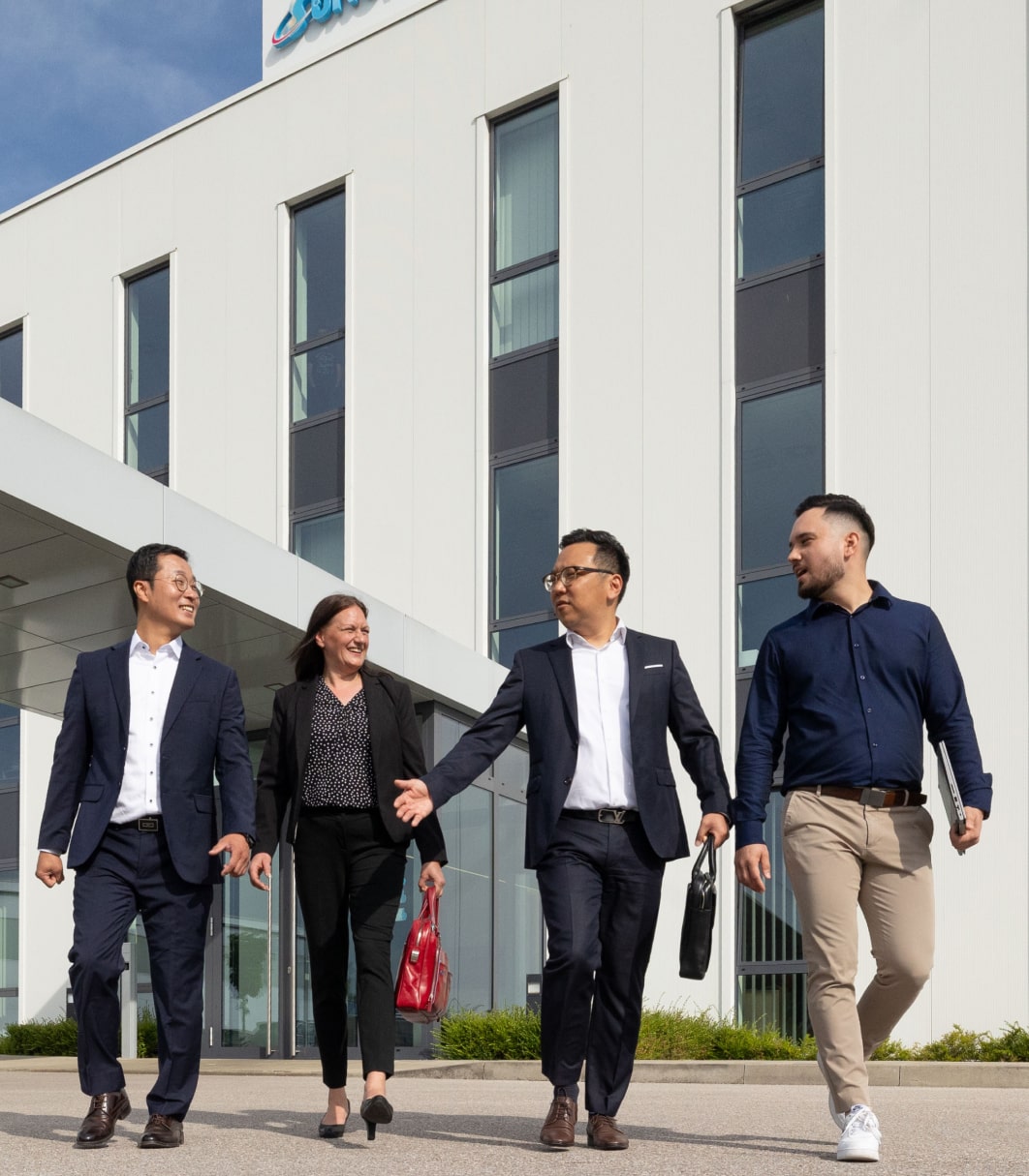 Eine Personengruppe vor dem Gebäude von Sungwoo Hightech.